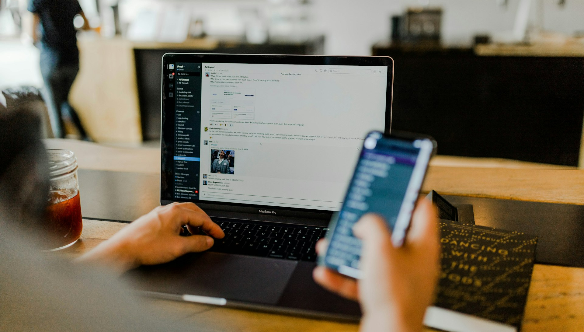person using phone and laptop